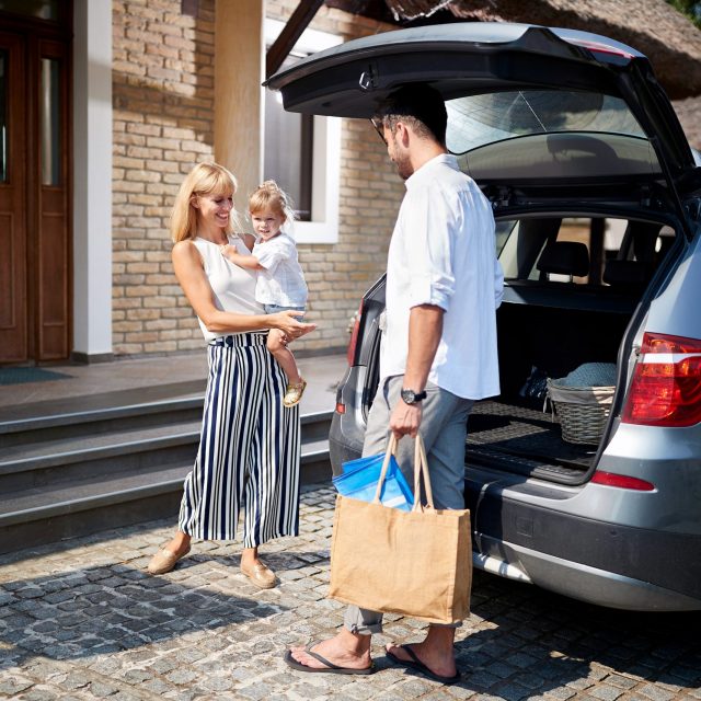 Family with baggage returns to home Family with little girl and baggage returns to home